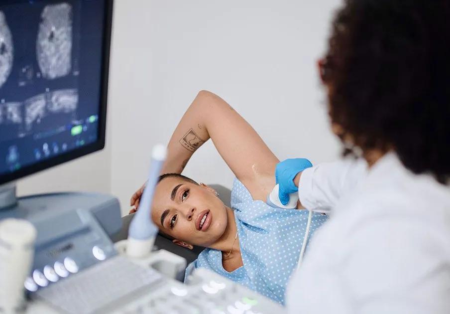 Une femme est en train de passer une échographie mammaire.