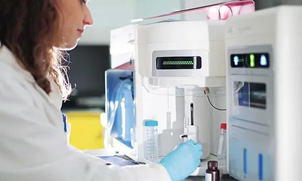 Analyse et manipulation d'une cellule cancéreuse par une chercheuse en laboratoire.