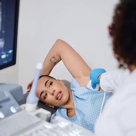 Une femme est en train de passer une échographie mammaire.