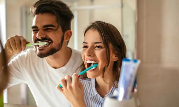 Un jeune couple se brosse les dents