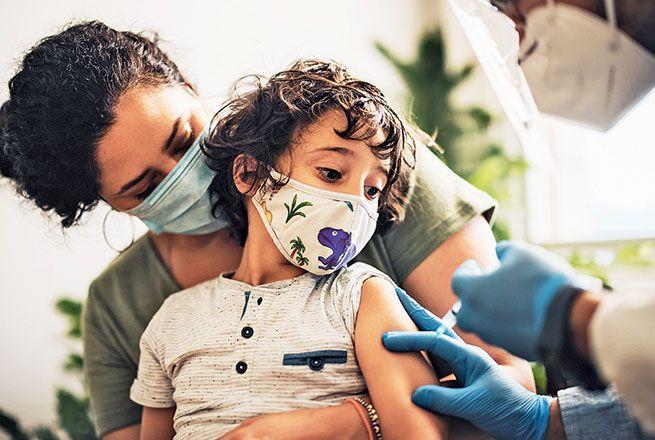 Un enfant se fait vacciner par un médecin.